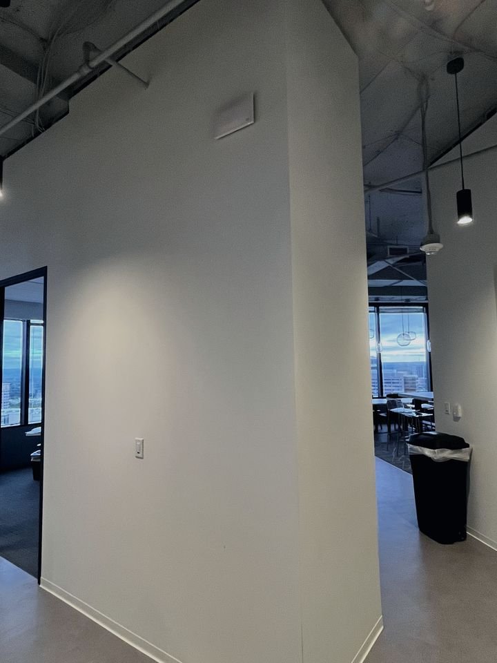 Wireless access point mounted high on an office corridor wall